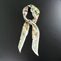 Detalle de un pañuelo de seda con estampado floral, bayas rojas y borde geométrico verde - 33x105cm / Verde