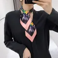 Floral silk-like skinny scarf in black and pink styling tied around the neck - Black Pink Base