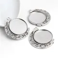 Close-up of three rotating 25mm silver alloy pendant trays with carved patterns for DIY jewelry - White K/Silver