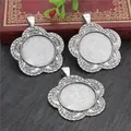 Three vintage silver flower alloy pendant bases for DIY jewelry making on a wood desk - Retro Flower Pendant Base Style (A5-17)