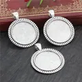 Three 25mm vintage silver alloy pendant trays for DIY jewelry on a dark wood background - Rope Texture Round Style (A5-21)