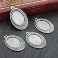 Pack of 4 antique silver oval alloy pendant trays with dotted edges on a vintage desk - Antique Silver Dotted Oval Pendant Base (D2-45)