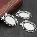 Three antique silver dove-edged oval pendant trays for DIY jewelry making on wood back - Antique Silver Oval Twin Bird Bezel