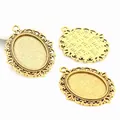Detail view of oval alloy pendant bases with antique bronze finish and filigree edge - Antique Gold