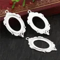 Three vintage silver oval pendant trays with baroque floral edges on dark wood background - Silver