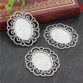 Three antique silver oval lace alloy pendant bases for DIY jewelry making on wood desk - Antique Silver Oval Filigree