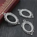 Detailed macro view of three vintage silver oval pendant trays on dark wood background - Antique Silver