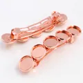 Detail van twee roségouden veerhaarklemmen met vijf ronde DIY-trays voor sieraden - Roségoud