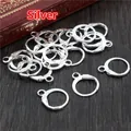 Dormeuses argentées pour création de bijoux DIY posées sur une surface en bois - Argent