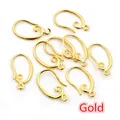 Macro detail of French gold-plated copper fishhook ear wires with spiral coil for DIY - Gold