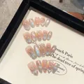 Detalle de uñas postizas hechas a mano con perlas blancas y pedrería sobre base nácar - Extra Pequeño (XS) / Estilo Ovalado Corto (2110)