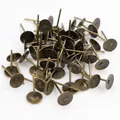 Macro detail of bulk antique bronze flat pad ear studs for DIY jewelry making - 4mm / Bronze