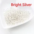 Primo piano di anellini aperti in argento lucido per gioielli fai-da-te in piatto bianco - 0.5x3mm (200 Pezzi/Confezione) / Argento