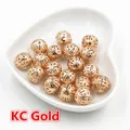 Detailed macro view of hollow gold metal beads for jewelry making in a heart-shaped tray - 6mm (100 Pieces/Pack/20g) / KC Gold