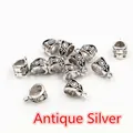 Macro detail of antique silver alloy bail beads with engraved floral scroll patterns - Antique Silver