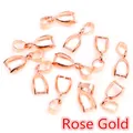 Close-up of rose gold plated pinch bails for pendants scattered on white background - Rose Gold