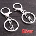 Set of two silver lobster clasp keychains with flat rings on dark walnut background - Silver