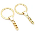 Dettaglio macro di un anello portachiavi piatto dorato da 30 mm con catena in lega - Oro