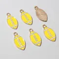 Macro detail of yellow enamel rugby charms with golden edges for jewelry making - Yellow