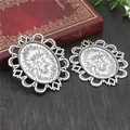 Macro view of two vintage 30x40mm silver oval pendant trays on dark wood background - Antique Silver Oval Lace Style (B3-24)
