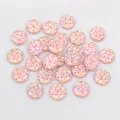 Macro view of 12mm peach pink faceted resin cabochon with shimmering texture - Light Pink (Z6-07)