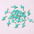Macro shot of turquoise enamel lightning bolt charms with golden metal hooks for DIY jewelry - Teal Green (E2-99)