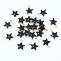 Macro view of black enamel star pendants with golden metal edges for DIY jewelry making - Black