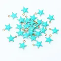 Macro detail of blue star-shaped enamel pendants with gold edges for DIY jewelry making - Teal