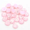 Primo piano di cabochon tondi in resina rosa con glitter e inserti in conchiglia per fai-da-te - 8mm / Rosa