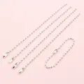 Close-up of five silver 2mm iron ball chains with connector clasps on pink background - Silver