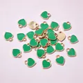 Macro detail of mini heart enamel charms with gold base for DIY jewelry making - Green