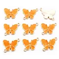 Vista detallada de conectores de mariposa de esmalte naranja y aleación dorada para joyería - Paquete de 10 / Naranja