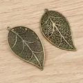 Antike Bronze Filigran-Blattanhänger auf Holzgrund für DIY-Schmuckhandwerk - Bronze