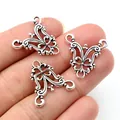 Three vintage silver filigree alloy pendant connectors held by hand against a white background - Antique Silver