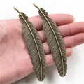 Paar große Federn-Anhänger aus Bronzelegierung für DIY-Schmuck, in der Hand zur Größe - Bronze