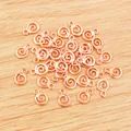 Spiralförmige Roségold-Legierung Anhänger für DIY-Schmuck auf hellem Holzuntergrund - Roségold