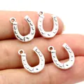 Close-up of four antique silver horseshoe charms held in hand for DIY jewelry making - Grooved Antique Silver Style (R6-06)