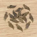 Makroaufnahme von Vintage-Bronze-Flügelanhängern mit Federstruktur für DIY-Schmuck - Bronze
