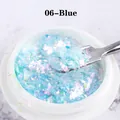 Macro shot of 06-Blue iridescent opal nail flakes in a jar with a metal sampling spoon - Blue (06)