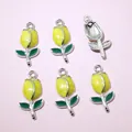 Macro view of six yellow tulip flower charms for DIY jewelry making with silver hooks - Yellow