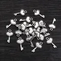Silver vintage heart key pendants for DIY necklaces and bracelets on wooden background - Antique Silver
