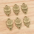 Set of 6 antique bronze owl pendants for DIY jewelry making on a wood background - Bronze