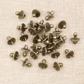 Macro view of bronze pacifier charms for DIY jewelry making on burlap background - Bronze