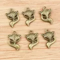 Set of 6 vintage bronze fox head pendants for DIY jewelry making on wood background - Bronze