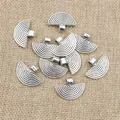 Macro detail of fan-shaped vintage silver charms with textured concentric arcs and loop - Antique Silver