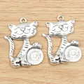 Detailed macro of two antique silver lucky cat pendants for DIY jewelry making - Antique Silver
