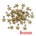 Macro shot of bronze star-shaped pendants for DIY jewelry making with a small loop - Bronze