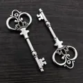 Vintage silver alloy key charms with ornate crown and heart engraving on wooden background - Antique Silver