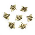Macro detail of antique bronze bee charms with intricate wing textures for DIY jewelry - Bronze
