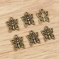 Antique bronze butterfly pendants for jewelry making displayed on a wooden surface - Bronze